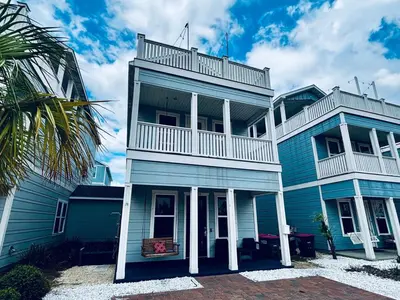 a blue house with a balcony on top of it at The Salty Blue in Panama City Beach