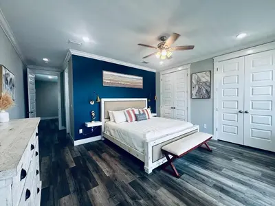 a bedroom with a bed and a blue wall at The Salty Blue in Panama City Beach