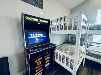 a room with a video game and two bunk beds at The Salty Blue in Panama City Beach