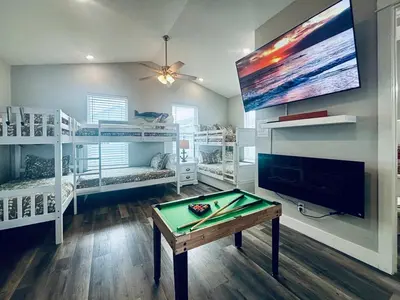 a room with a pool table and a tv at The Salty Blue in Panama City Beach
