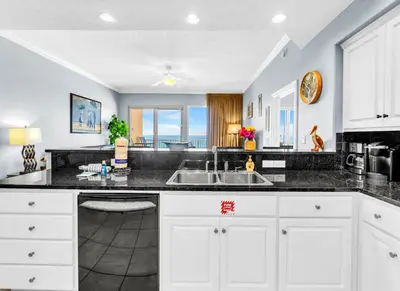 a kitchen with white cabinets and a sink at Treasure Island 511 in Panama City Beach