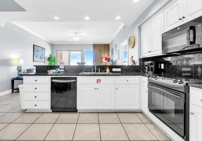 a large kitchen with white cabinets and appliances at Treasure Island 511 in Panama City Beach