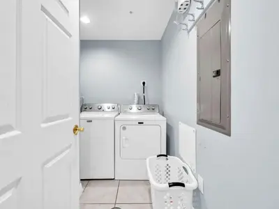 a small white kitchen with a washer and dryer at Treasure Island 511 in Panama City Beach
