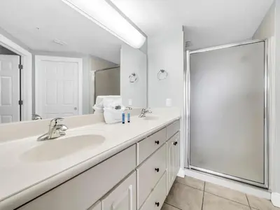 a white bathroom with a sink and a shower at Treasure Island 1102 in Panama City Beach