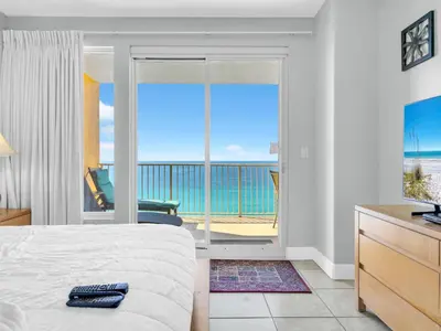 a bedroom with a bed and a view of the ocean at Treasure Island 1102 in Panama City Beach