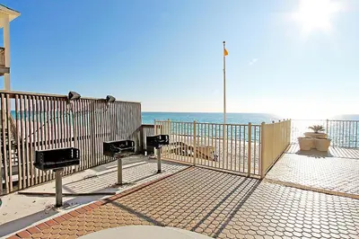 a fence on the beach with the ocean in the background at Treasure Island 1102 in Panama City Beach