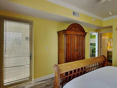 a bedroom with a bed and a wooden cabinet at Shores of Panama #1501 in Panama City Beach