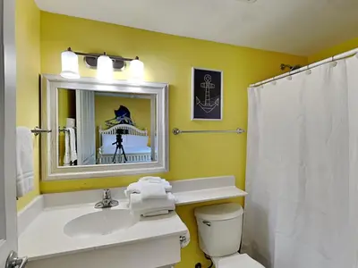 a bathroom with a sink and a toilet and a mirror at Shores of Panama #1501 in Panama City Beach