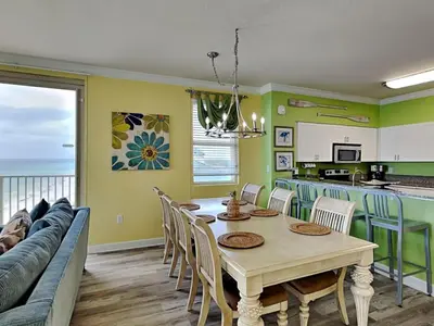 a kitchen and dining room with a table and chairs at Shores of Panama #1501 in Panama City Beach