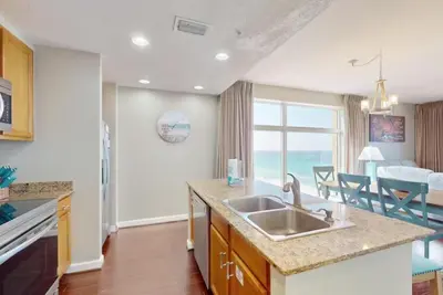a kitchen with a sink and a view of the ocean at Sterling Reef 501 by Emerald Coast Reteats in Panama City Beach