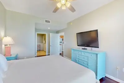 a bedroom with a bed and a flat screen tv at Sterling Reef 501 by Emerald Coast Reteats in Panama City Beach