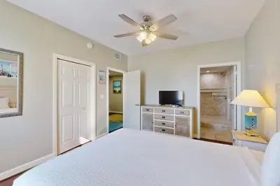 a bedroom with a white bed and a ceiling fan at Sterling Reef 501 by Emerald Coast Reteats in Panama City Beach