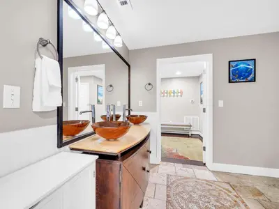 a bathroom with two bowl sinks on a wooden counter at Sterling Reef 501 by Emerald Coast Reteats in Panama City Beach