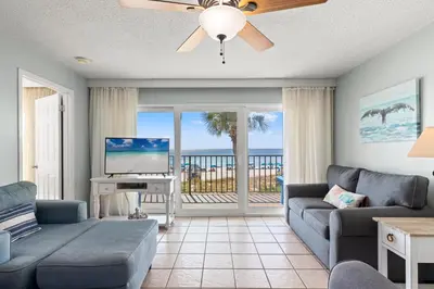 a living room with a couch and a flat screen tv at Commodore 0201 in Panama City Beach
