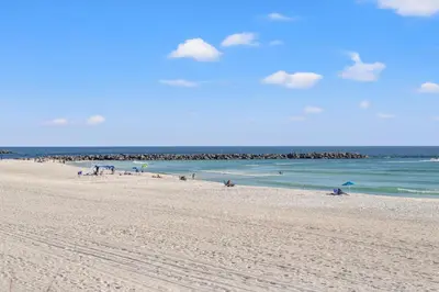 a group of people on a beach with the ocean at Commodore 0201 in Panama City Beach