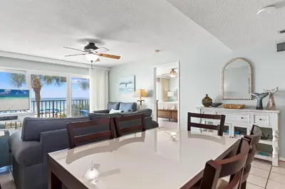 a living room with a couch and a dining room at Commodore 0201 in Panama City Beach