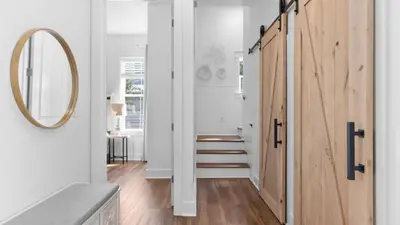 a hallway with a wooden door and a mirror at Family-Friendly 30A Stay Pool Access Firepit Steps to the Beach Driftwood Dreams by AvantStay in Inlet Beach