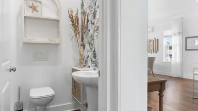 a white bathroom with a toilet and a sink at Family-Friendly 30A Stay Pool Access Firepit Steps to the Beach Driftwood Dreams by AvantStay in Inlet Beach