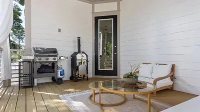 a screened porch with a couch and a stove at Family-Friendly 30A Stay Pool Access Firepit Steps to the Beach Driftwood Dreams by AvantStay in Inlet Beach