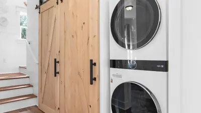 a laundry room with a washer and dryer next to a door at Family-Friendly 30A Stay Pool Access Firepit Steps to the Beach Driftwood Dreams by AvantStay in Inlet Beach