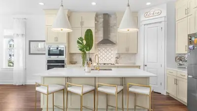 a kitchen with white cabinets and a large island with stools at Family-Friendly 30A Stay Pool Access Firepit Steps to the Beach Driftwood Dreams by AvantStay in Inlet Beach