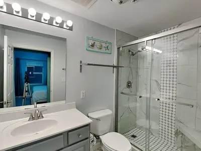 a bathroom with a shower and a toilet and a sink at Seychelles #203 in Panama City Beach