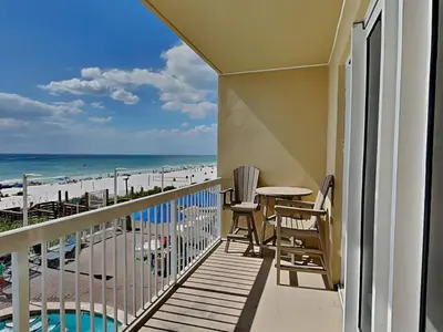 a balcony with a table and chairs and the beach at Seychelles #203 in Panama City Beach