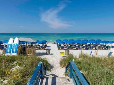 a beach with chairs and umbrellas and the ocean at Seychelles #203 in Panama City Beach