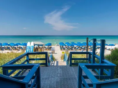 a walkway to the beach with chairs and umbrellas at Seychelles #203 in Panama City Beach