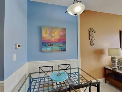a blue room with a glass table and chairs at Seychelles #203 in Panama City Beach
