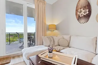 a living room with a couch and a balcony at Family-Friendly Laketown Wharf Retreat w/ Pools & Walk to Beach in Panama City Beach