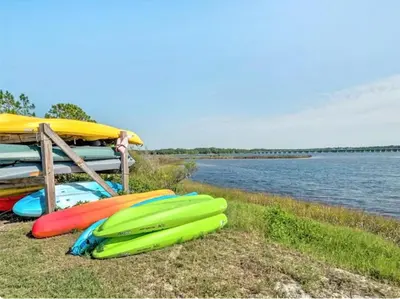 a group of surfboards sitting on the grass near a body of water at Sand, Sea & Air at Pinnacle Port A-301 in Panama City Beach