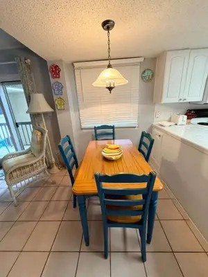 a kitchen with a wooden table and chairs in a kitchen at Sand, Sea & Air at Pinnacle Port A-301 in Panama City Beach