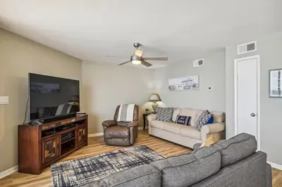 a living room with a couch and a tv at Aquavista 603W by Emerald Coast Retreats in Panama City Beach