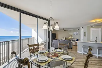 a dining room and living room with a view of the ocean at Aquavista 603W by Emerald Coast Retreats in Panama City Beach