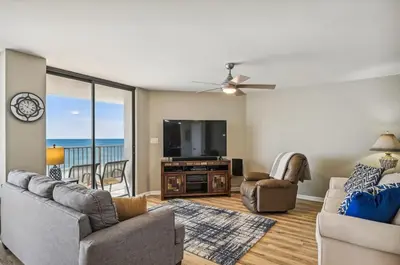 a living room with a couch and a flat screen tv at Aquavista 603W by Emerald Coast Retreats in Panama City Beach