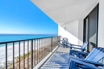 a balcony with blue chairs and the ocean at Aquavista 603W by Emerald Coast Retreats in Panama City Beach