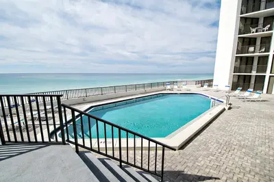 a swimming pool next to a balcony with the ocean at Aquavista 603W by Emerald Coast Retreats in Panama City Beach