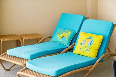 a blue rocking chair with two pillows on it at Luxury 2BR Beachfront Condo - Panama City Beach in Panama City Beach