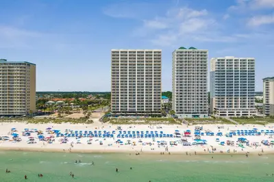 a beach with many umbrellas and people on it at Luxury 2BR Beachfront Condo - Panama City Beach in Panama City Beach