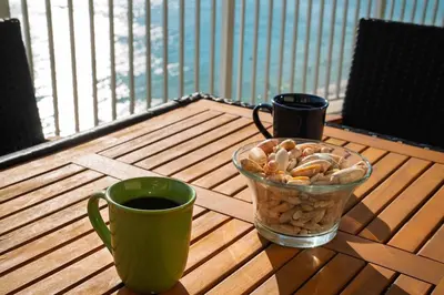 a table with a cup of coffee and a vase of nuts at Luxury 2BR Beachfront Condo - Panama City Beach in Panama City Beach
