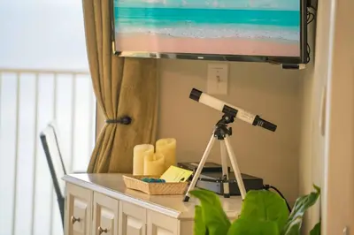 a telescope sitting on a table next to a television at Luxury 2BR Beachfront Condo - Panama City Beach in Panama City Beach