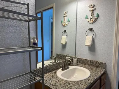 a bathroom with a sink and a mirror at Beautiful Resort Condo Panama City Beach King Bed in Panama City Beach
