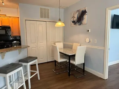 a kitchen and dining room with a table and chairs at Beautiful Resort Condo Panama City Beach King Bed in Panama City Beach