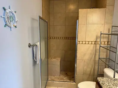 a shower with a glass door in a bathroom at Beautiful Resort Condo Panama City Beach King Bed in Panama City Beach