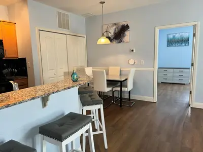 a kitchen and dining room with a table and chairs at Beautiful Resort Condo Panama City Beach King Bed in Panama City Beach