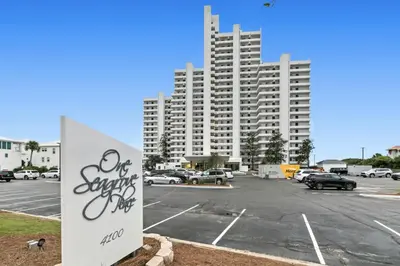 a parking lot with a large building in the background at Book Me Baby! The One at One Seagrove Place in Seagrove Beach