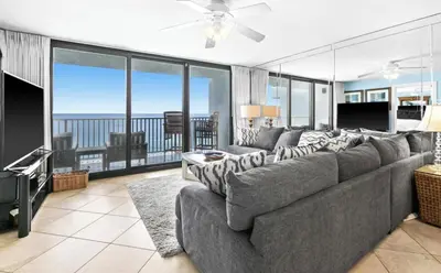 a living room with a large couch and a television at Book Me Baby! The One at One Seagrove Place in Seagrove Beach
