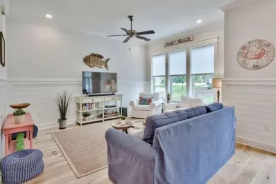 a living room with a blue couch and a tv at Book Me Baby Big Chill in Prominence Golf Cart Included in Inlet Beach