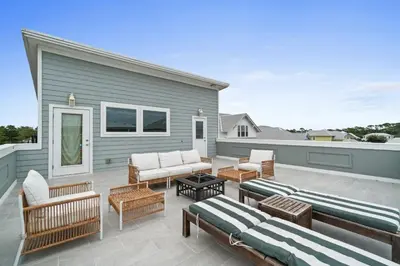 a patio with chairs and tables on top of a house at Know When To Hold Em in Inlet Beach in Inlet Beach